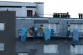 Warsaw, Poland - November 10, 2021: Insulation of an apartment block with polystyrene. Construction workers on scaffolding.