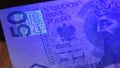 Warsaw, Poland 01.01.2021 Polish zloty under the UV lamp. Testing paper money for counterfeiting concept. extreme close Royalty Free Stock Photo