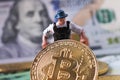 WARSAW / POLAND - September 23 2018: bitcoins new virtual currency. A worker is digging on golden bitcoin with dollar background Royalty Free Stock Photo