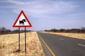 Warthog crossing sign on namibian road Royalty Free Stock Photo