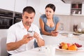 Wary woman looking at phone of husband