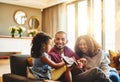 She was born into a musical family. an adorable little girl and her parents playing a guitar together on the sofa at