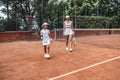 That was a great game! Full length shot of little girl tennis player and her female tennis trainer. Sporty child and sporty pretty Royalty Free Stock Photo