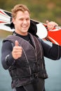 That was great. Smiling water-skier holding his skis alongside the lake and giving a thumbs up. Royalty Free Stock Photo