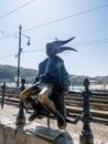 The statue of the Little Princess statue sitting on the railings of the Danube promenade in Budapest,