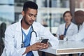 That was such a beautiful message. a young male doctor using his smartphone while taking a break. Royalty Free Stock Photo