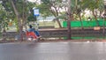 because he was tired, the rickshaw puller rested under the bus stop sign