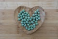 Wasabi Coating Roasted Peanuts on a wooden heart container