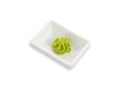 Wasabi in a white rectangular gravy boat. Seasoning for sushi. White background. Isolated