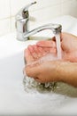 Wash basin and running water from the tap in bathroom Royalty Free Stock Photo