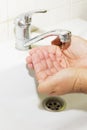 Wash basin and running water from the tap in bathroom Royalty Free Stock Photo