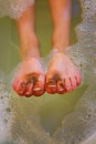 Wash child with dirty feet in the bath with water