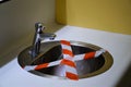 Washbasin in public sanitary with cordoned off piece due to corona keep a distance of 1.5 meters against contamination.