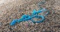 Washed ashore frayed blue braided synthetic rope from close