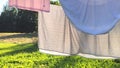 Washed clean laundry hanging on the rope or clothesline drying in the wind outdoors