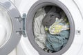 Washed cotton bed linen and towels in washing machine drum, close up