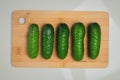 washed fresh cucumbers on a wooden cutting board. Top view, seasonal harvest