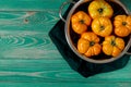 Washed various tomatoes in a colander on a wooden background