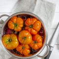 Washed various tomatoes in a colander on a wooden background
