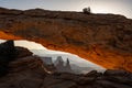 The Washer Woman Stands Tall Through The Glowing Orange Rock of Mesa Arch