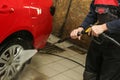 Washerman`s hands are washing car by washing gun close up.