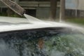 Washes the roof of the car. The flow of water from the hose to the car Royalty Free Stock Photo