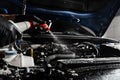 Washing car engine with spray and detergent in detailing auto service. Detailing cleaning motor from dust and dirt Royalty Free Stock Photo