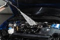 Washing car engine with with water in detailing auto service. Detailing cleaning motor from dust and dirt. Pouring water Royalty Free Stock Photo