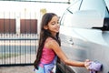Washing car, happy and child with water, home chores and cleaning. Smile, routine and a little girl with happiness while Royalty Free Stock Photo