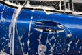 Washing a car. Soapy blue car. Car wash with foam. Machine service.