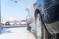 Washing car wheel by water pressure at self-service station