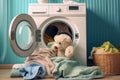 Washing children's clothes. Washing machine with a clean washed towel and a teddy bear in the laundry room