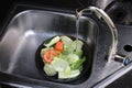 Washing colorful fruits and vegetables in the kitchen sink