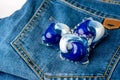 Washing detergent capsule pod on jeans Royalty Free Stock Photo