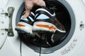 Washing dirty sneakers in the washing machine. Cleaning trail running shoes Royalty Free Stock Photo