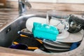 Washing dishes by hand. Pile of dirty dishes and soapy sponge in stainless steel kitchen sink Royalty Free Stock Photo