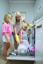 Washing dishes has never been easier. a mother and her two little daughters using a dishwashing machine at home. Royalty Free Stock Photo