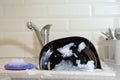 Washing dishes in the kitchen. Dirty dishes plates and glasses, lie in the sink in white foam. front view. homework Royalty Free Stock Photo