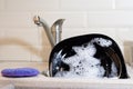 Washing dishes in the kitchen. Dirty dishes plates and glasses, lie in the sink in white foam. front view. homework Royalty Free Stock Photo