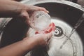 Washing dishes with sponge in woman`s hand in kitchen sink Royalty Free Stock Photo