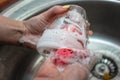 Washing dishes with sponge in woman`s hand in kitchen sink Royalty Free Stock Photo