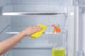 Washing fridge. hand Cleaning Refrigerator. fridge cleaning - spray bottle with detergents for washing the fridge Royalty Free Stock Photo