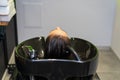 Washing hair on a blurred backdrop of a beauty salon. Background, selective focus Royalty Free Stock Photo