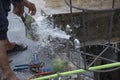 Washing hand,legs and plumbing tools with the burst water pipe splashing.