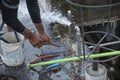 Washing hand,legs and plumbing tools with the burst water pipe splashing.