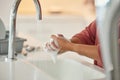 Washing hands, cleaning and person with hygiene and water for wellness in a kitchen faucet. Soap foam, sink and home Royalty Free Stock Photo