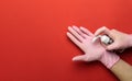 Washing hands  on red. Using medical sanitizer gel in lab gloves on red background. Clear sanitizer in pump Royalty Free Stock Photo