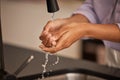 Washing hands, sink and water cleaning for wellness, health and hygiene hand care in a home. Person at a house kitchen Royalty Free Stock Photo