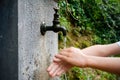 Washing kid`s hands under antique pipe