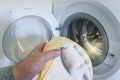 washing light-colored clothes in the washing machine. man holding a towel Royalty Free Stock Photo